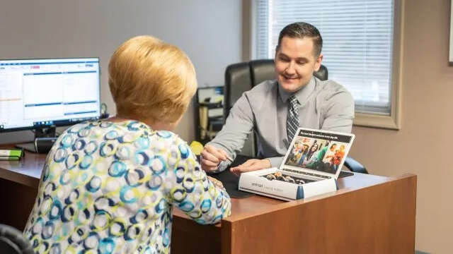 Adam Wentling showing patient new set of hearing aids